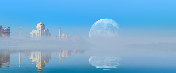 Taj Mahal mausoleum reflected in Yamuna river with early morning fog - Agra, Uttar Pradesh,...