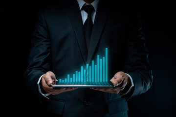 Businessman using tablet with chart hologram effect.