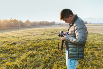 Photographer traveler adjusts the camera   lifestyle professional activity hiker landscape