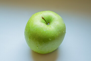 Green wet apple on white background.