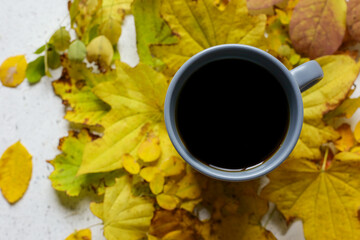 Yellow autumn leaves and cup of coffee