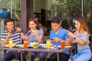 Group of young bloggers take photo of food on table