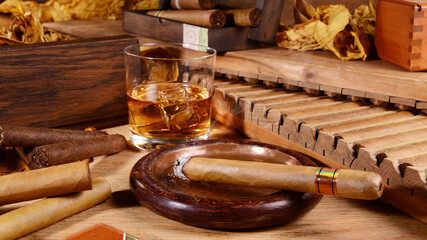 Cigars with Whisky and Tobacco Leaves on wooden Background © ExQuisine