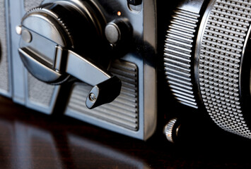 close-up, large-format camera (focus on film pass crank), on brown table