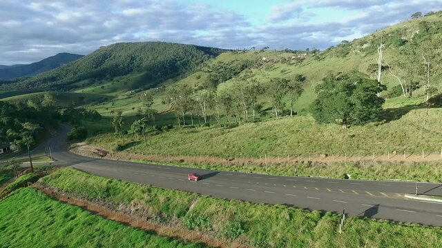 Aerial, pov, a red car on a steep, scenic route, Brazil