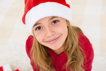 Young girl face in red santa hat with Child with Christmas concept, banner copy space. Top view.