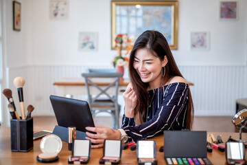 Young asian woman blogger recording video makeup cosmetic at home. Selling products online concept.