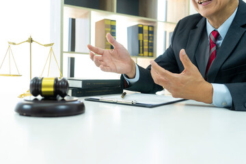 A lawyer is consulting a legal job in his office had gavel and balance