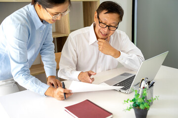 Diverse male mentor and intern talking pointing on paper