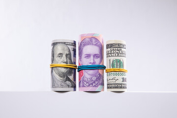 rolls of dollars and hryvnias isolated on white background, close view