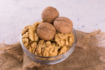 A bowl of peeled walnuts on a white background.
Close-up.