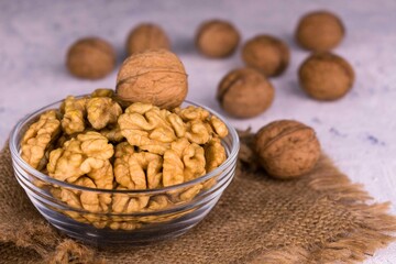 
Shelled walnuts in a transparent glass bowl.
Close-up.