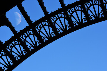 Eiffel tower arches and rising moon