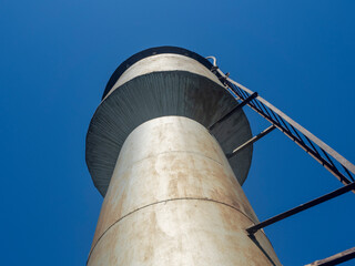 bottom view of an Old metal water tower on a Sunny day in the Russian countryside in summer.