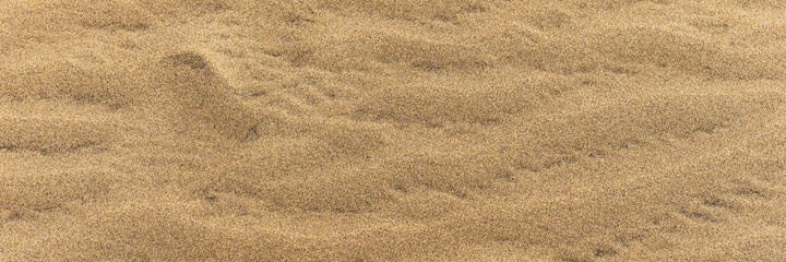 Fototapeta na wymiar Panoramic sandy background. Sand on the beach formed by wind
