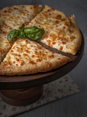 food photography of traditional homemade georgian baked hot bread - khachapuri - flatbreads with cheese side view on brown wooden stand close up