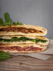 food photography of three ways of stuffed khachapuri with spinach, red beans and meat, traditional homemade georgian baked hot flatbreads with cheese. Сlose-up cut front view on gray background