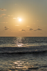 Vertical shot of an admirable sunset on a wavy sea