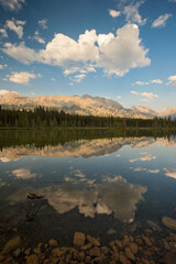 summers afternoon in the Kananaskis country of Alberta Canada. Lakes reflecting colorful clouds with wildflowers all around
