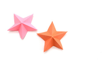 two holiday paper stars on white