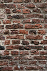 old wall made of rectangular red bricks sealed with cement