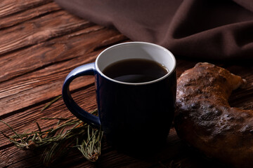 Homemade pastries and a cup of tea on an old wooden surface. Homemade strudel. Anise and fragrant herbs on the table. Low key photo.