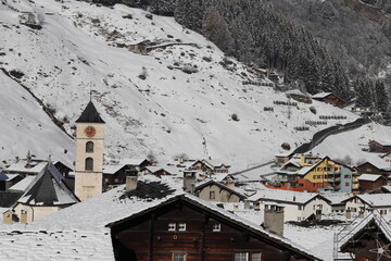 Church with golden red clock in vals switzerland. Winter landscape in the background
