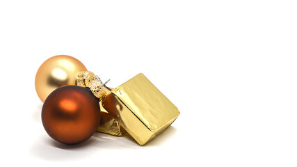 Christmas card: Christmas balls in cream and gold colors and square gift boxes in a golden wrapper on a white background. Space for text on the right.