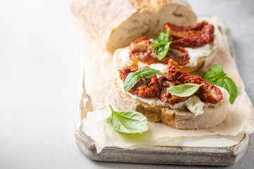 Bruschetta with sundried tomatoes, cottage cheese and fresh basil. Tasty savory Italian appetizers