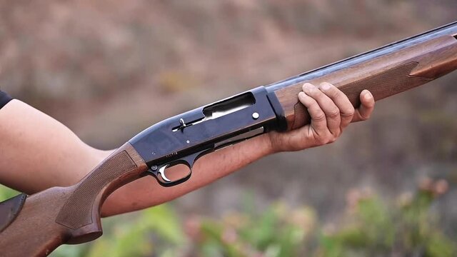 Close up of a hunter hands unloading a shotgun. Slow motion. High quality FullHD footage