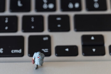 miniature men on computer keyboard