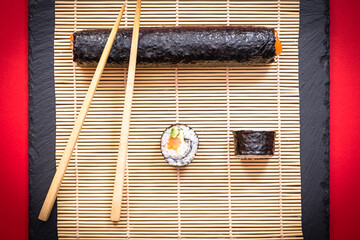Présentation de plat de cuisine Japonaise, dés de saumon, sushi et maki sur fond noir avec...