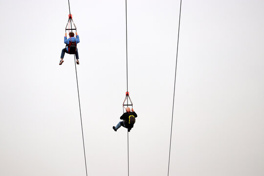 Couple On The Zipline On Sky Background, Bottom View