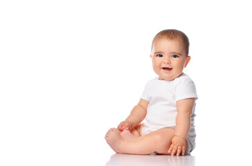 Adorable little baby smiling, sitting on the floor, studio shot, isolated on white background,...