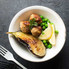 Meat balls for lunch with grilled eggplant and fresh green peas as a garnish. Healthy snack balanced diet. Top view