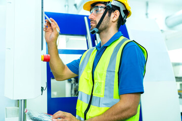 young caucasian technicians work manage  inspecting with control screen computer the work process of industrial CNC metal machining in clean room On High-Tech modern Factory business ind