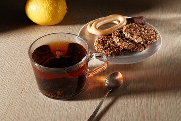 Cup of tea on the table in the morning light with a plate of cookies