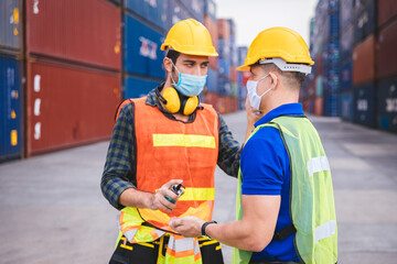 Worker scanning fever temperature with digital thermometer to construction site staff wearing hygiene face mask protect from Coronavirus or COVID-19. New Normal working life adaptation in 2020