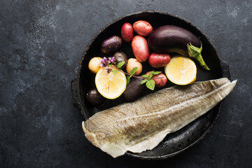 Skinned white sea fish cod fillet with ingredients for simple homemade healthy comfort food. Top...