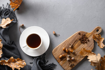 Acorn coffee with fall oak leaves and cozy scarf on gray concrete table. Coffee substitute without...
