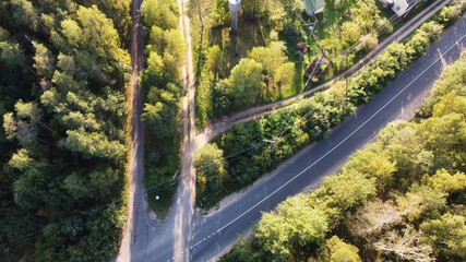 Top view of the highway through the forest on a sunny day