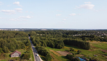 Fototapeta na wymiar Top view of the highway through the forest on a sunny day