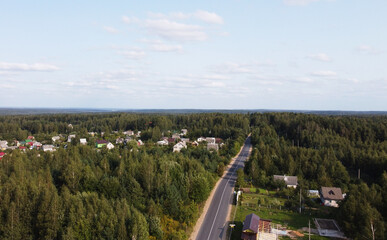 Top view of the highway through the forest on a sunny day