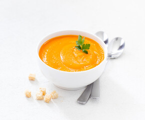 Carrot soup-puree in a bowl with croutons on a white background