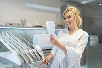 Portrait of young smiling female dentist in modern dental office