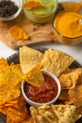 Close-up of traditional mexican corn tortilla chips with salsa and cheese dip. Tasty meal. Food concept. White background.