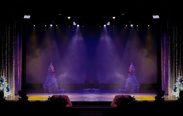 Theater before the performance of artists. Bright colored light and scene with Christmas trees.