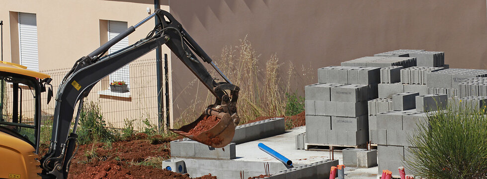 Travaux de terrassement avec une mini pelleteuse sur le chantier de construction d'une maison