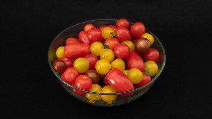
Small multicolored tomatoes in a glass bowl