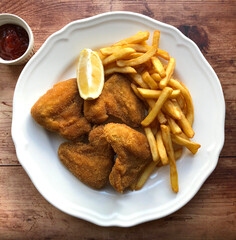 Breaded chicken wings, also known as breaded fried chicken wings are coated in egg, flour and breadcrumbs, then deep fried to golden brown and served with french fries, ketchup and lemon.